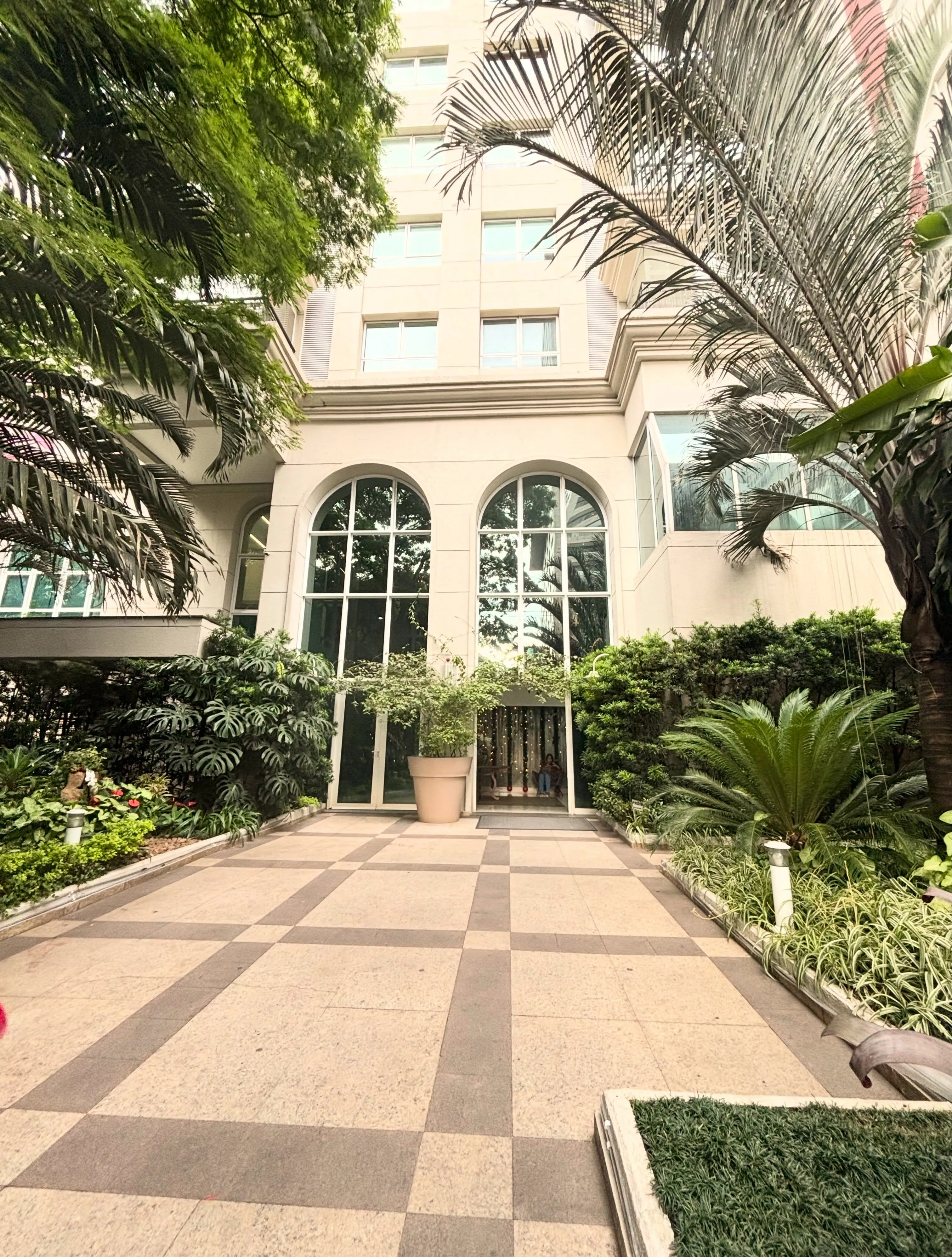 Entrada do edifício do Espaço Azura, com jardim e janelas em arco