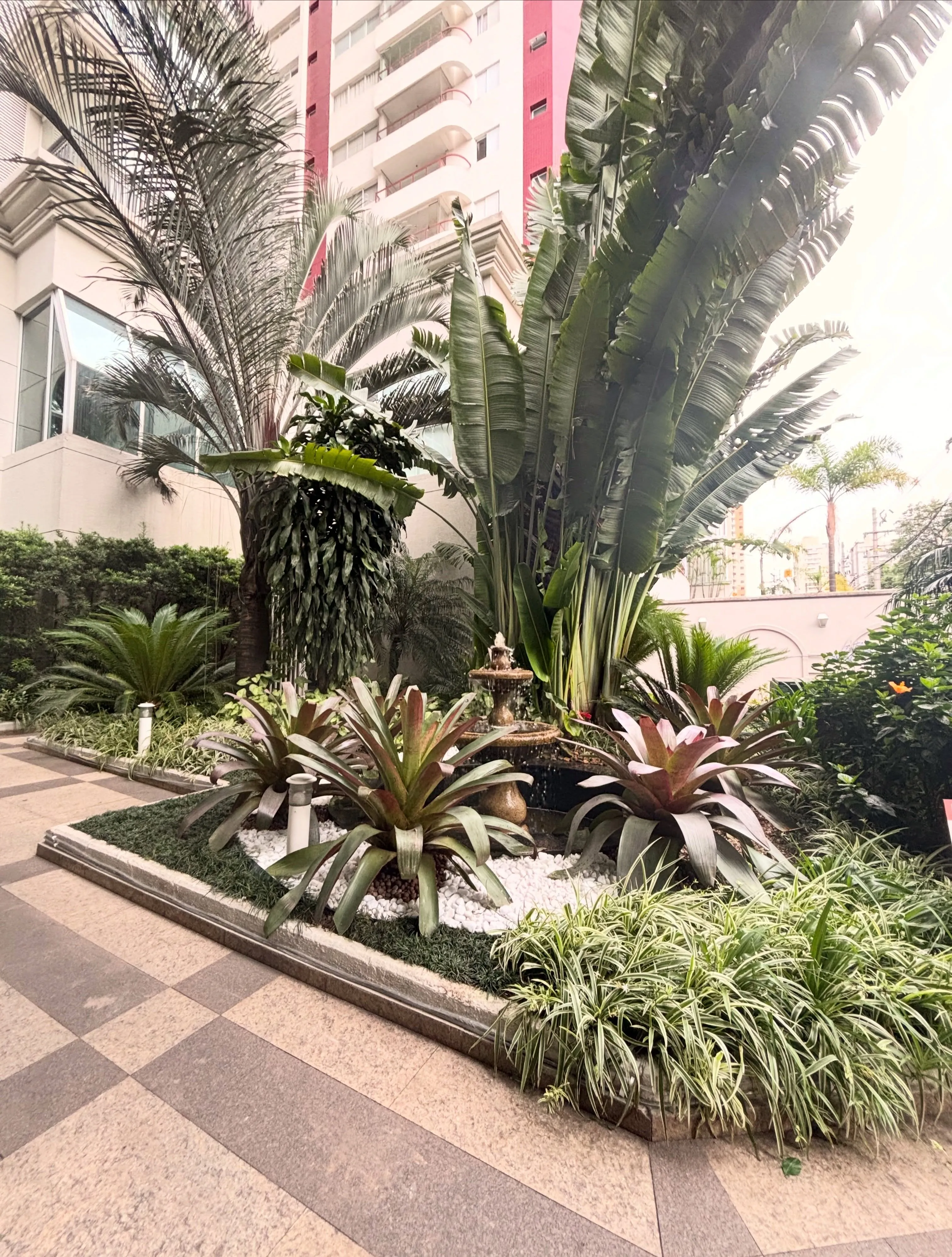 Jardim com fonte na entrada do edifício